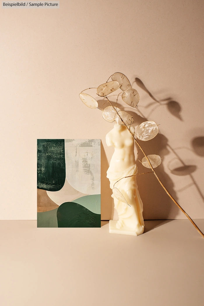 Abstract art with green and beige shapes beside a white sculpture and dried branch casting shadows on a beige surface.