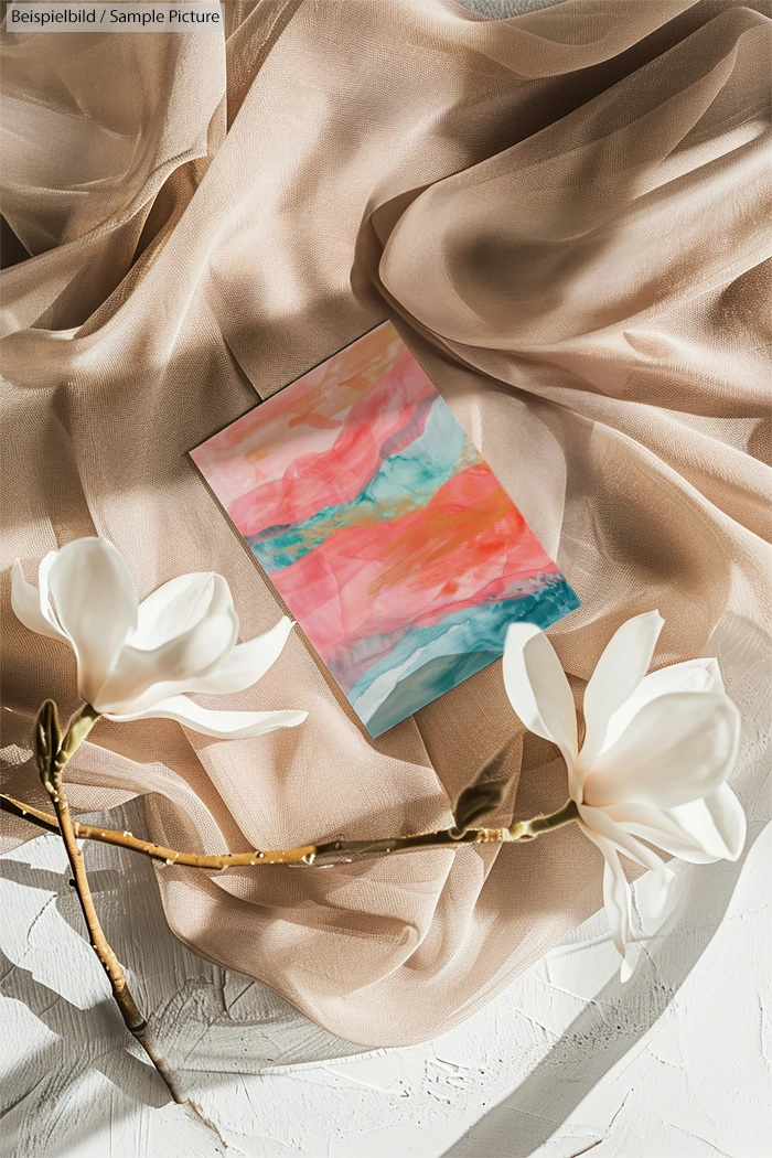 Colorful abstract painting on soft beige fabric with white magnolia flowers.