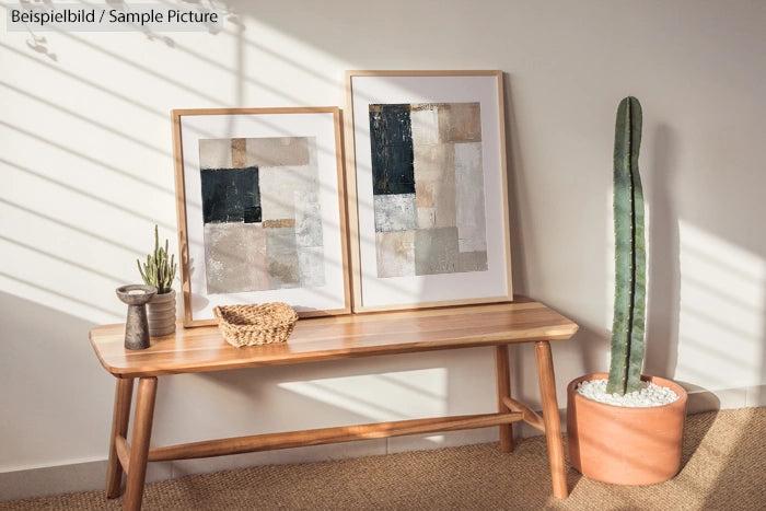 Wooden bench with abstract art on beige wall, potted cactus, and small plants in sunny room.