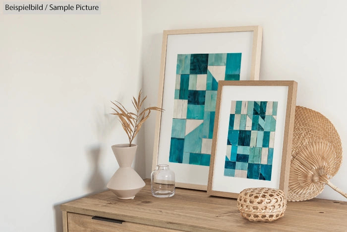 Framed abstract teal and beige artwork on a wooden shelf with decorative vases and a wicker basket.