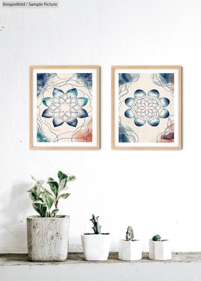 Two abstract flower art prints in wooden frames above potted plants on a white wall.