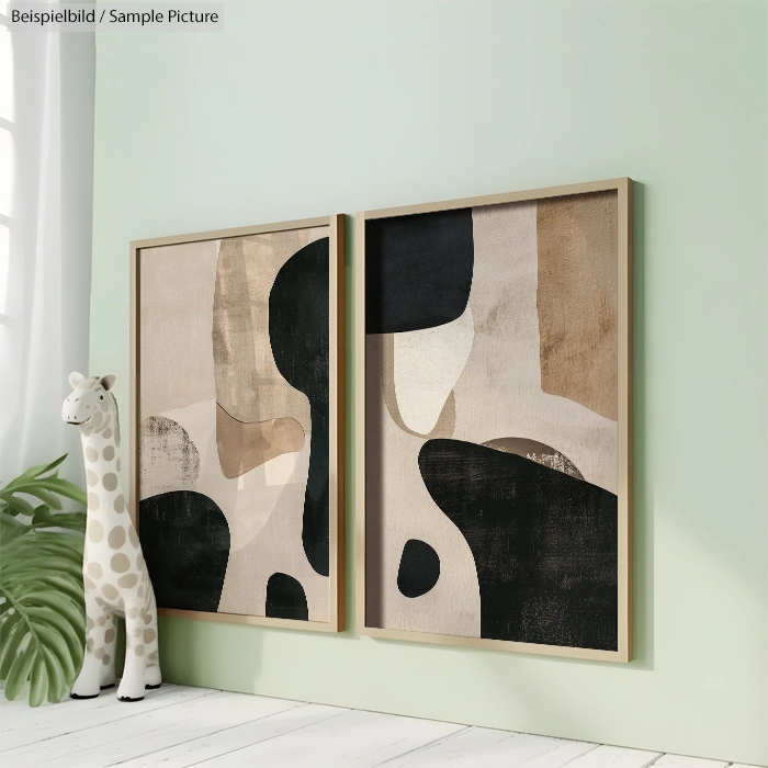 Two framed abstract paintings with neutral tones on a green wall beside a plush giraffe and a plant.