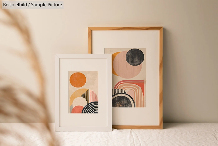 Framed abstract artworks with geometric shapes in a minimal setting.