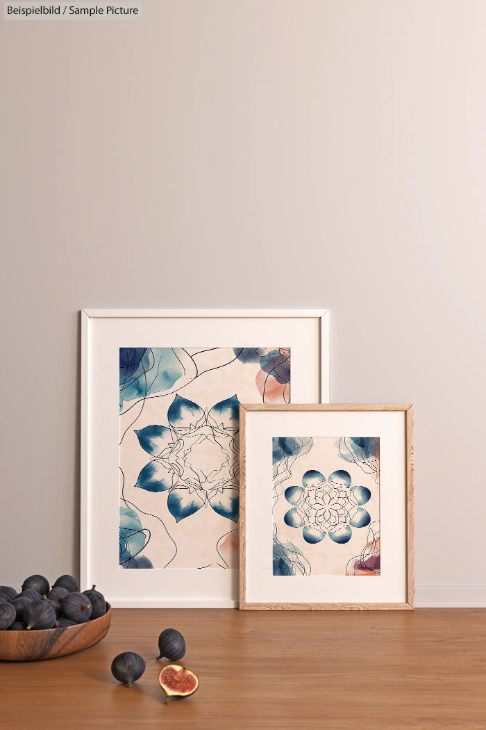 Two framed floral prints on a tabletop with figs; modern minimalistic decor against a beige wall.