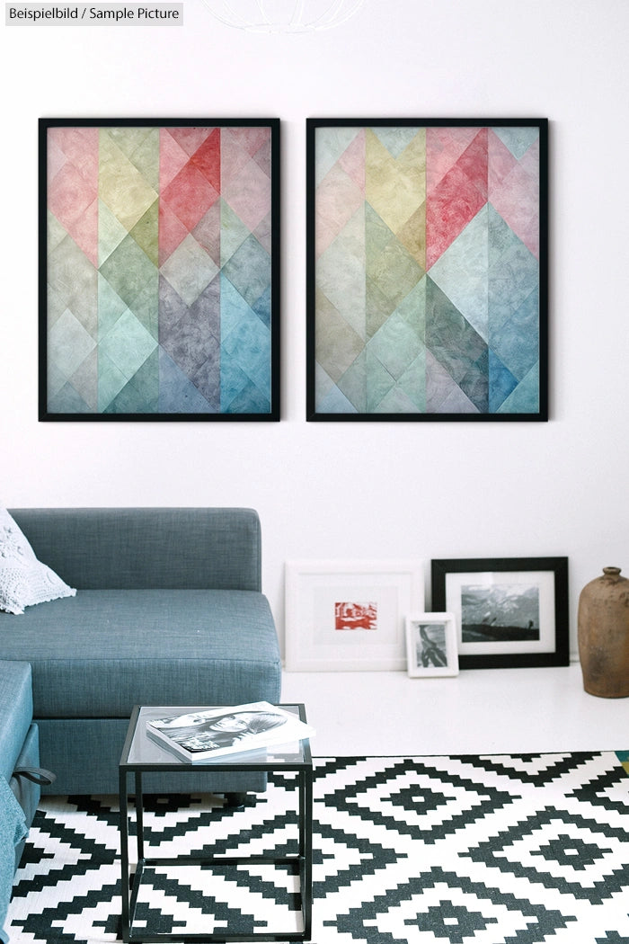 Modern living room with geometric art, blue sofa, black and white patterned rug, and framed photographs on the floor.