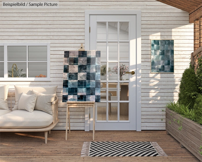 Outdoor terrace with abstract blue and gray artwork, white couch, and glass door reflecting garden.