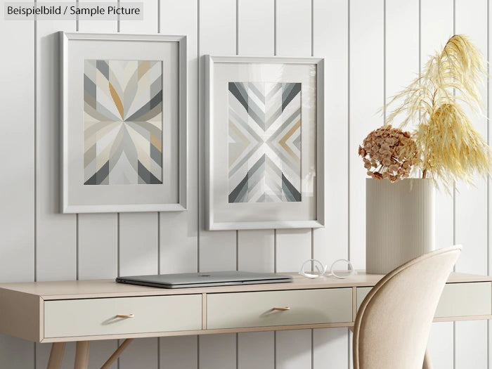 Modern workspace with abstract art, laptop, and decorative plants on a wooden desk against a white paneled wall.