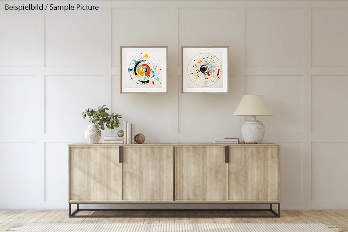 Modern living room with abstract art, wooden sideboard, decorative vase, and lamp against a paneled wall.