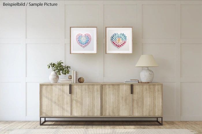 Minimalist living room with wooden sideboard, two framed heart artworks, and decorative items on top.