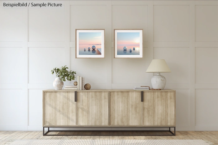 Modern living room with wood sideboard, two ocean sunset paintings, a lamp, and decorative plants on top.