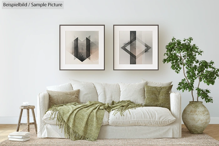 Living room with white sofa, green pillows, abstract art on wall, and a potted plant.