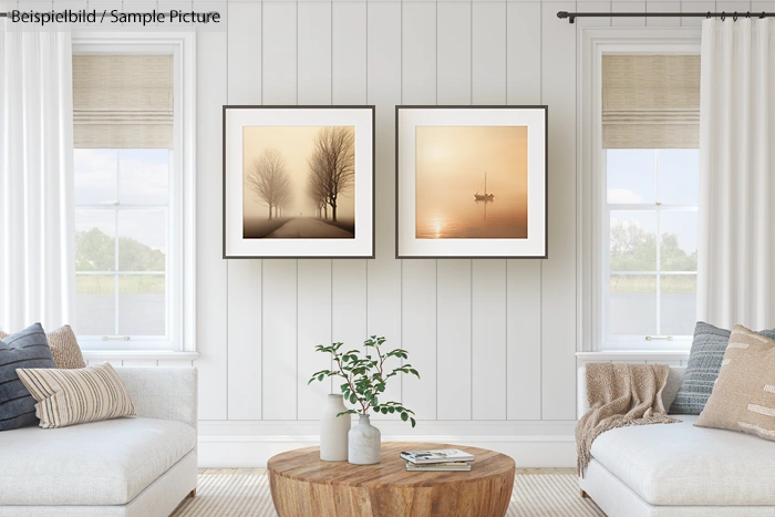 Modern living room with two framed landscape photos on a white paneled wall, featuring cozy sofas and a wooden coffee table.