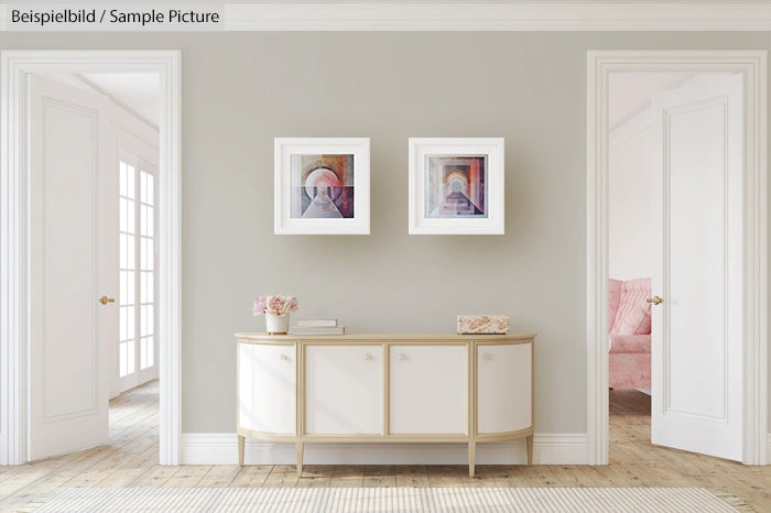 Minimalistic hallway with two abstract paintings, cream sideboard, and wooden floor.