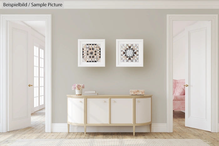 Elegant living room with a beige sideboard and framed geometric art on a light grey wall, doorways leading to seated area.