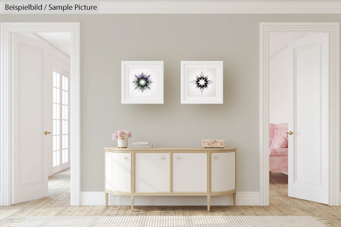 Minimalist living room with white sideboard, flower artwork, and adjoining room with pink armchair.