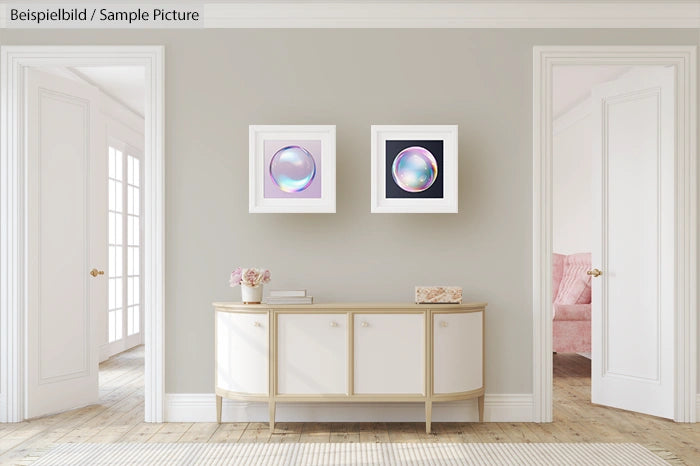 Contemporary living room with framed abstract art, white console table, decorative vase, and neutral tones.