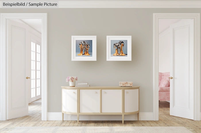 Elegant room with light gray walls, a sideboard, and two framed abstract paintings.