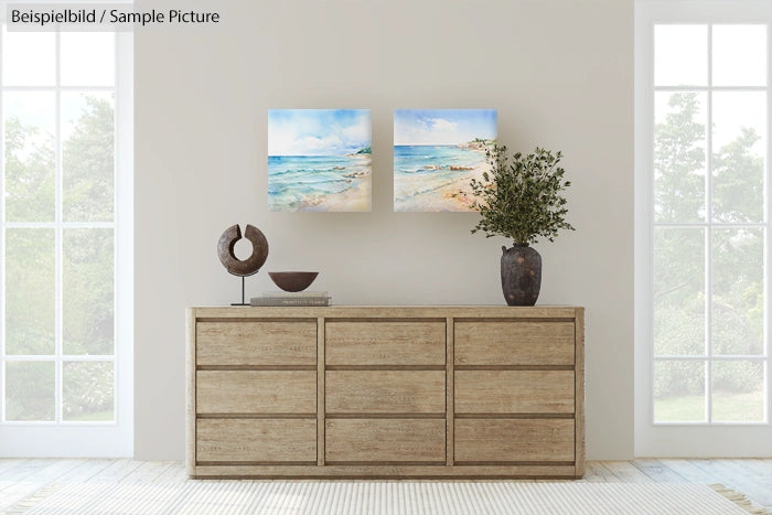 Minimalist room with wooden dresser, coastal paintings, potted plant, and a round sculpture on top.