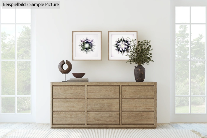 Minimalist room with wooden sideboard, decorative plant, and abstract floral framed art on white wall.