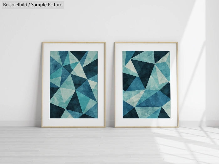 Two framed geometric abstract artworks with blue and teal triangular patterns on a white wall in a minimalist room.