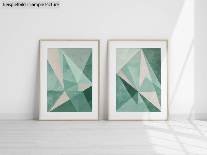 Two framed geometric art prints with green and beige triangular patterns hanging on a white wall.