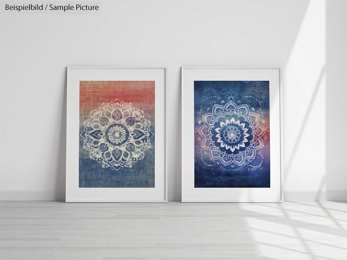 Two framed prints of intricate mandala designs, one with red tones and the other with blue, displayed on a wooden floor.