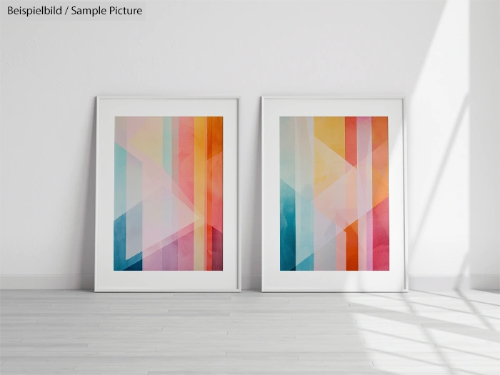 Two framed geometric abstract art pieces with colorful vertical and diagonal patterns leaning against a white wall.