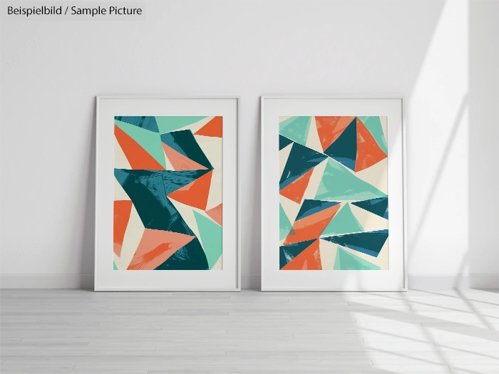 Two framed geometric abstract art prints with teal, orange, and cream triangles, displayed on a light wooden floor.