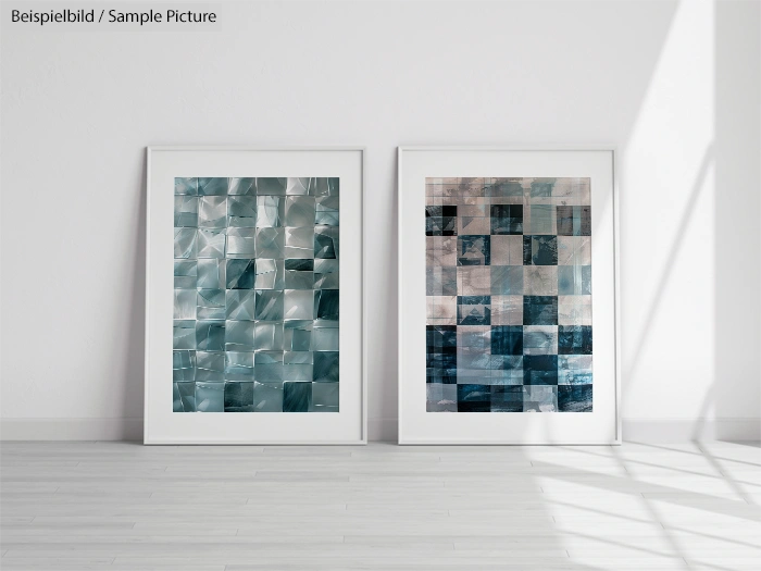 Two framed abstract art pieces with blue and gray geometric patterns, displayed on a wooden floor against a white wall.