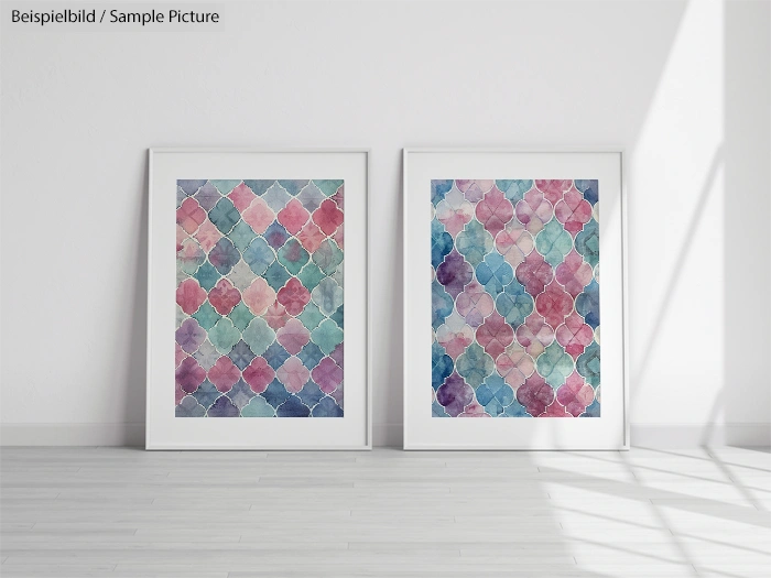 Two framed watercolor paintings with colorful geometric patterns on a white wall.