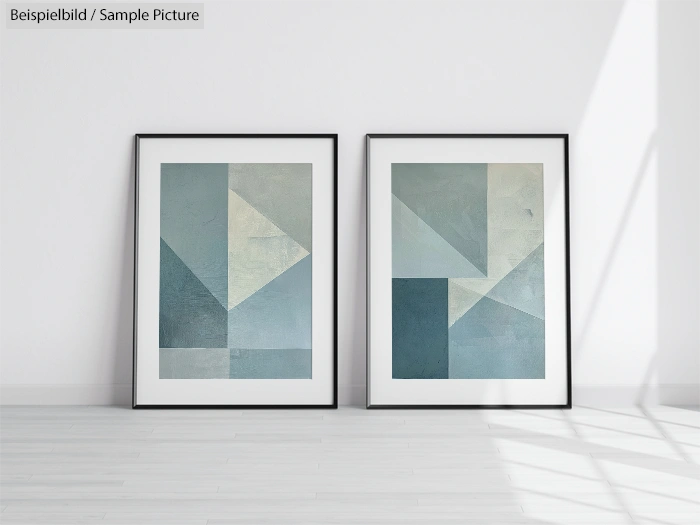 Two framed geometric abstract paintings with blue and gray shapes on a white wall.