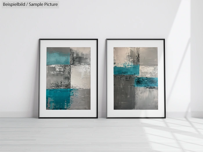 Two abstract paintings with blue, grey, and white geometric patterns in black frames on a white wall.