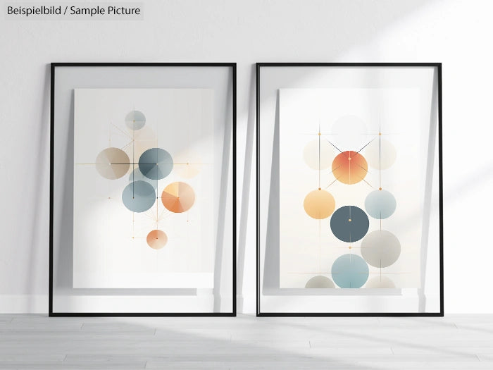 Framed abstract art prints with geometric circles in shades of blue and orange, displayed on a light-colored floor.