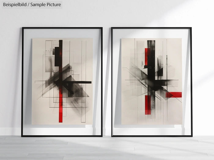 Pair of abstract geometric artworks with black and red shapes in frames, displayed on a floor.