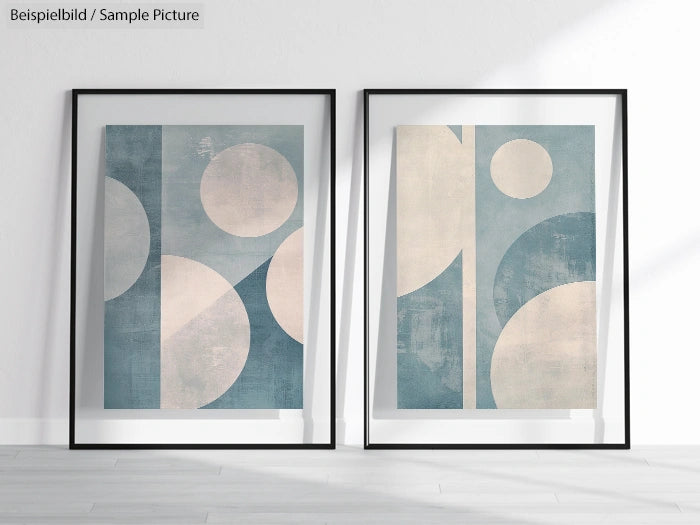 Pair of framed abstract artworks with geometric blue and beige shapes on a light wall.