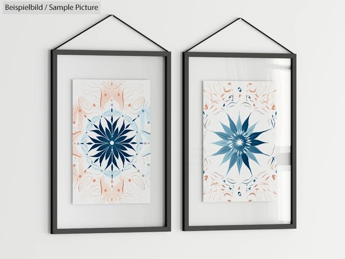 Two framed geometric prints with blue and orange abstract patterns, hanging side by side on a white wall.