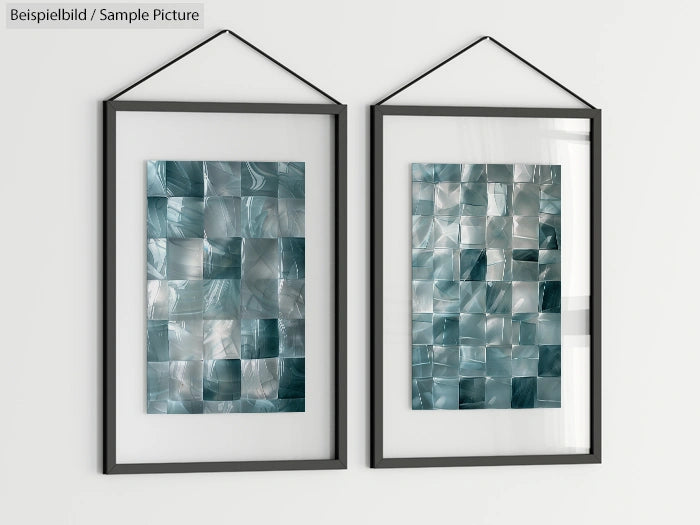 Two framed abstract artworks with metallic blue and silver tiles hanging on a white wall.