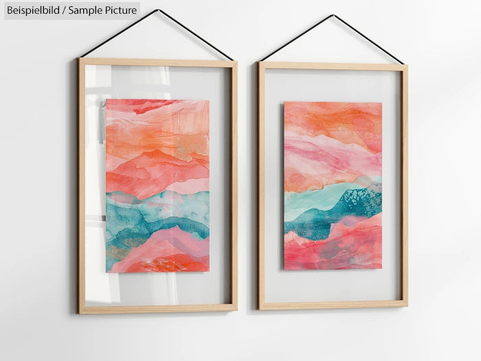 Two framed abstract paintings with red, pink, blue swirls, and watercolor textures, displayed on a white wall.