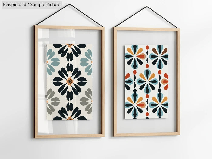 Two framed abstract floral patterns in muted colors, hung on a white wall.