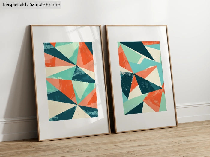 Two framed abstract geometric art prints with colorful triangles, leaning against a white wall on a wooden floor.