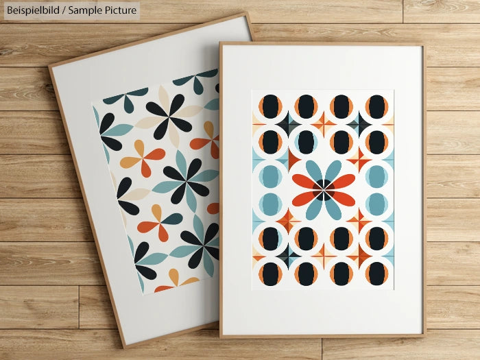 Two framed geometric art prints with floral and circular patterns on a wooden floor background.