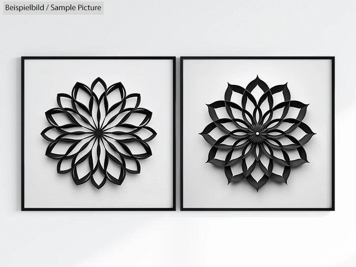 Two black geometric flower designs in square frames on a white wall.