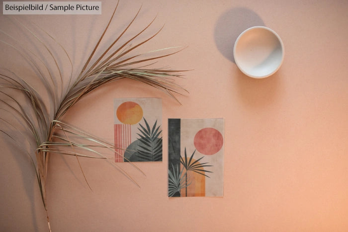 Minimalist artwork with plants and geometric shapes on a beige background, alongside a dried palm frond and bowl.