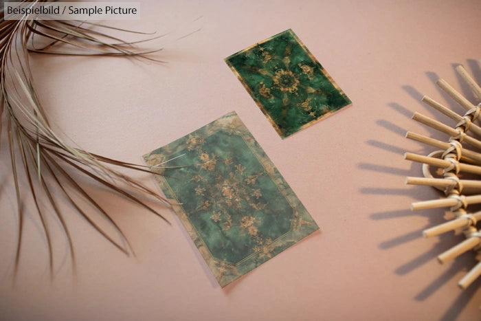 Two vintage green postcards on a beige surface, surrounded by dried grass and straw decorations.