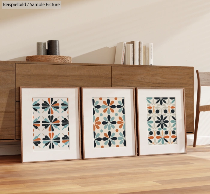 Elegant geometric art prints with floral patterns, displayed on a wooden floor in a minimalist room setting.