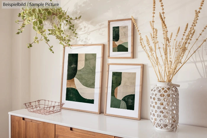 Minimalist art piece with green abstract shapes in wooden frames on a white tabletop.