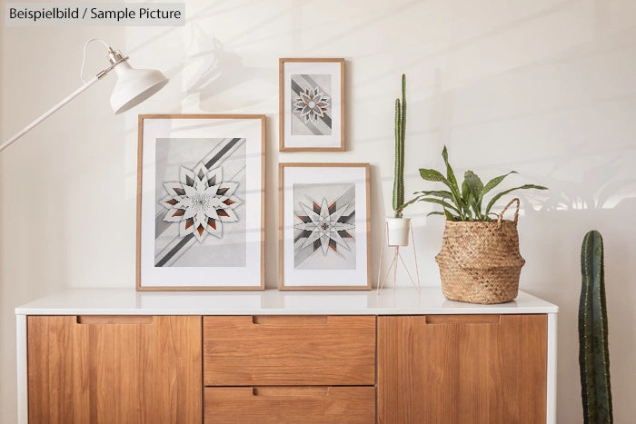 Modern interior with wood cabinet, framed geometric art, tall plants, and a white lamp.