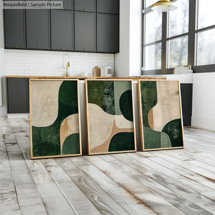 Abstract green and beige artwork in modern kitchen with dark cabinets and wooden floor.