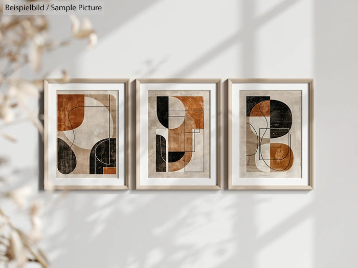 Three framed abstract artworks with geometric shapes in brown, black, and beige tones, hanging on a white wall.