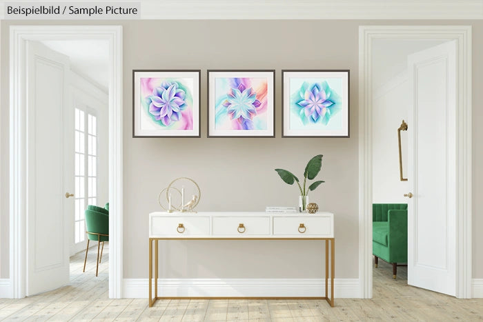 Modern hallway with three framed geometric art pieces on wall, white console table, plant and minimalist decor.